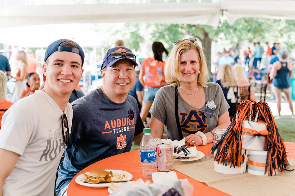A family sits at a table at a tailgate event