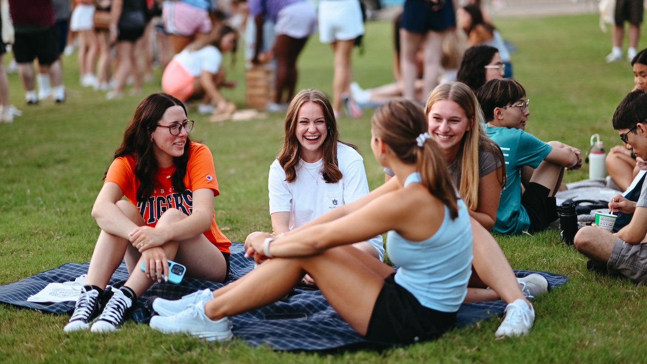 Women of Alpha Chi Omega dancing on stage in fringe pants