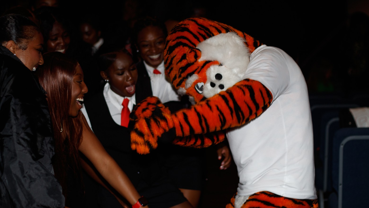 Students dancing with mascot.