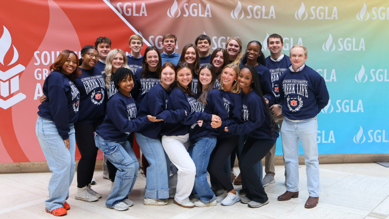 auburn university students in front of an SGLA backdrop