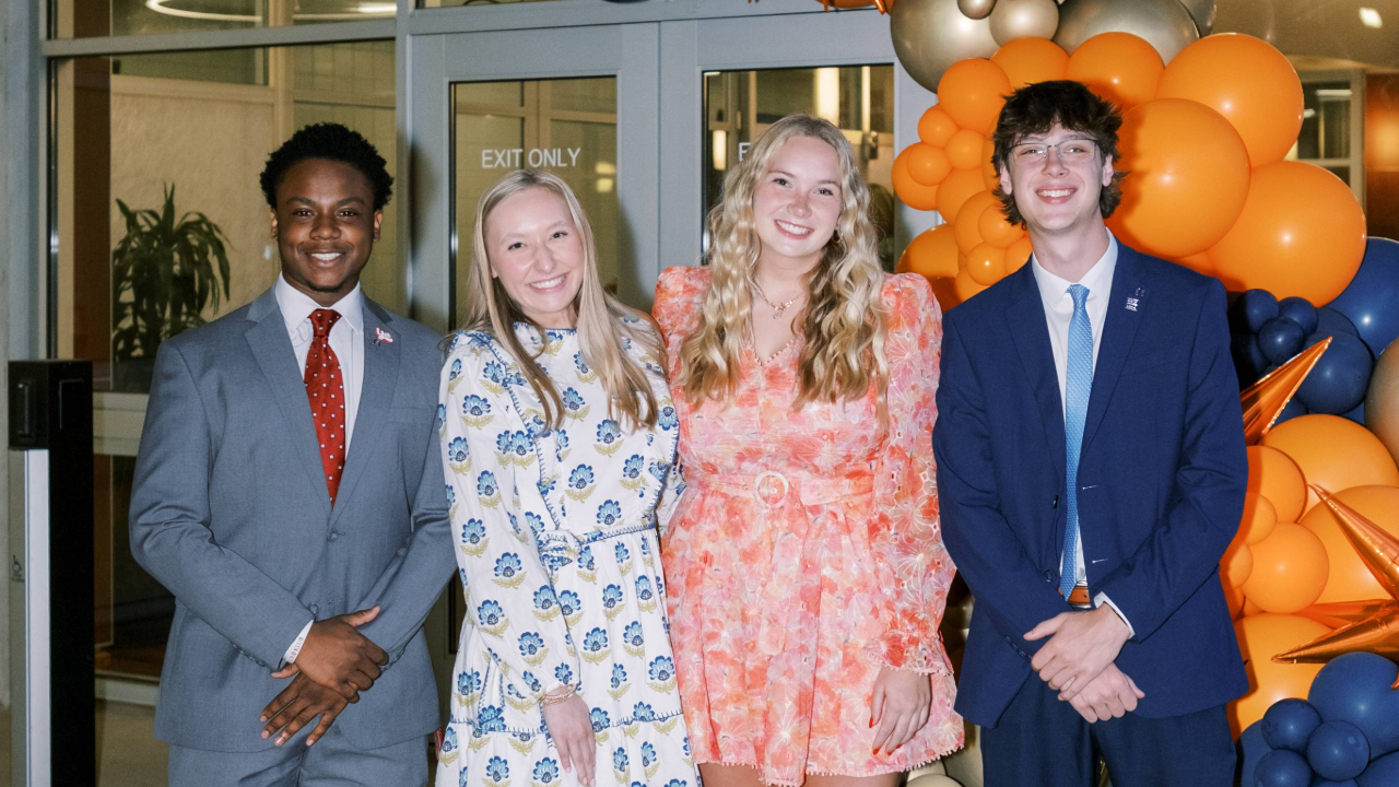 Four students smiling at the camera