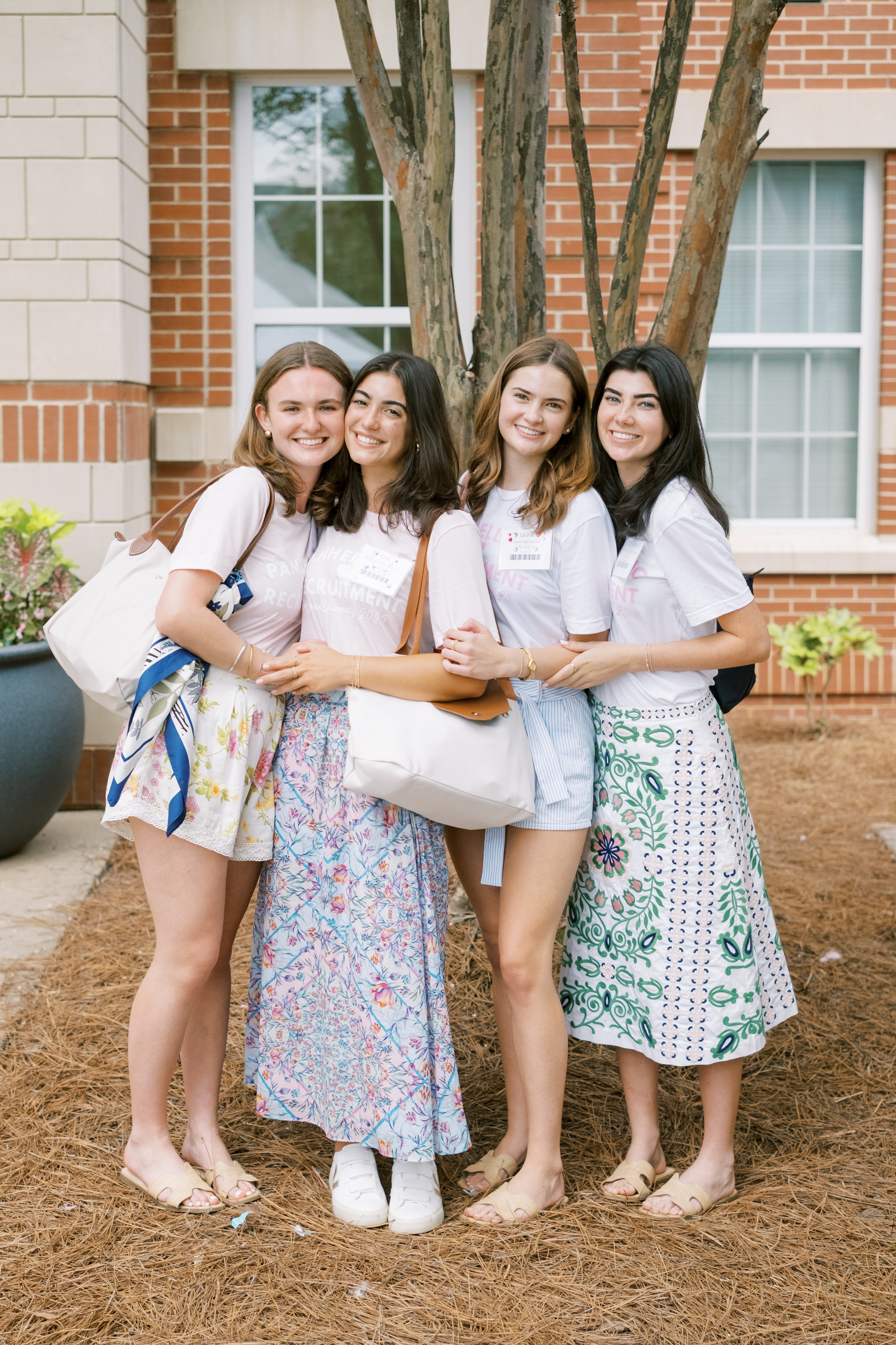 Four women hugging and smiling at the camera