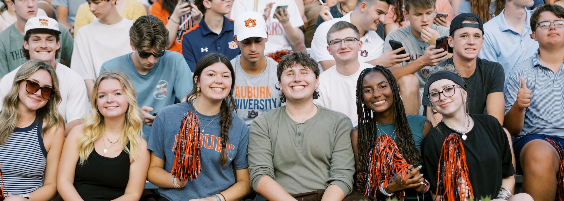 students sitting in Jordan-Hare Stadium smiling for the camera