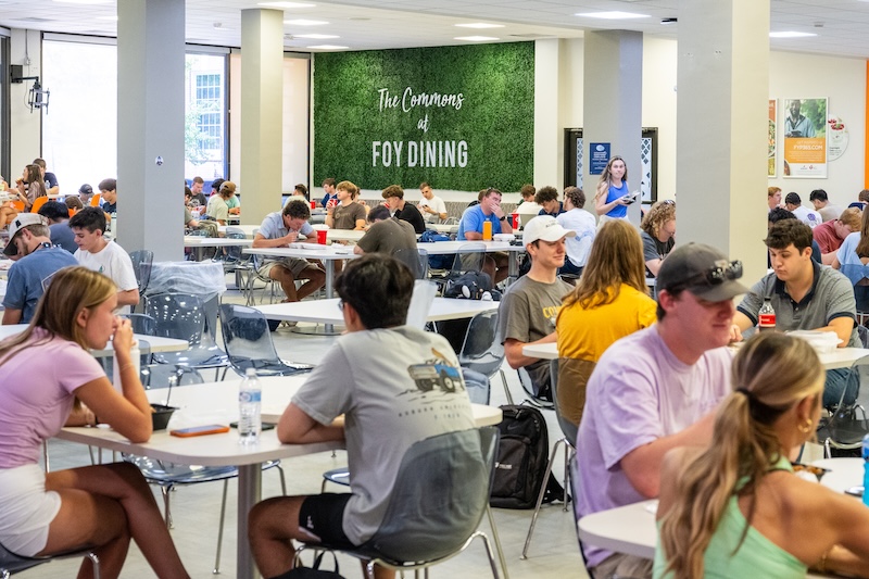students sitting and eating at tables in Foy commons