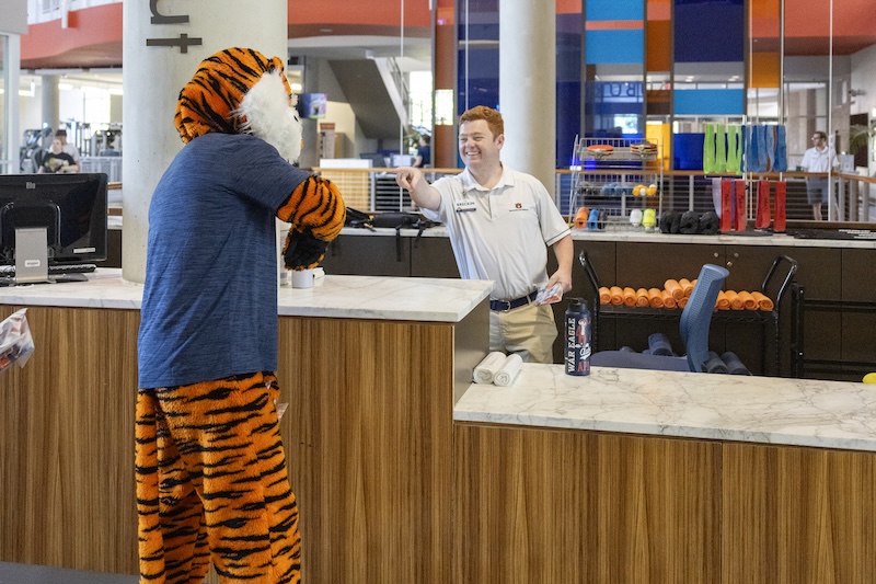 Aubie greeting a student worker at the campus rec check-in counter