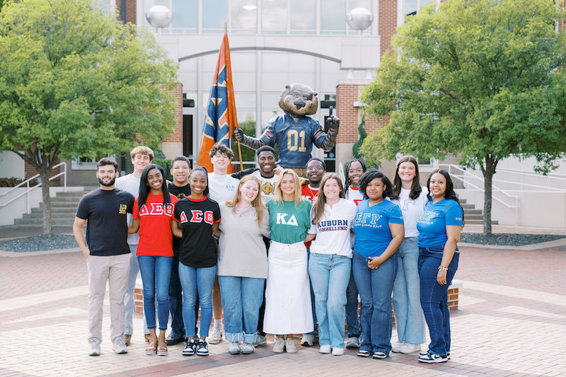 auburn greek leadership posing in front of the Aubie statue