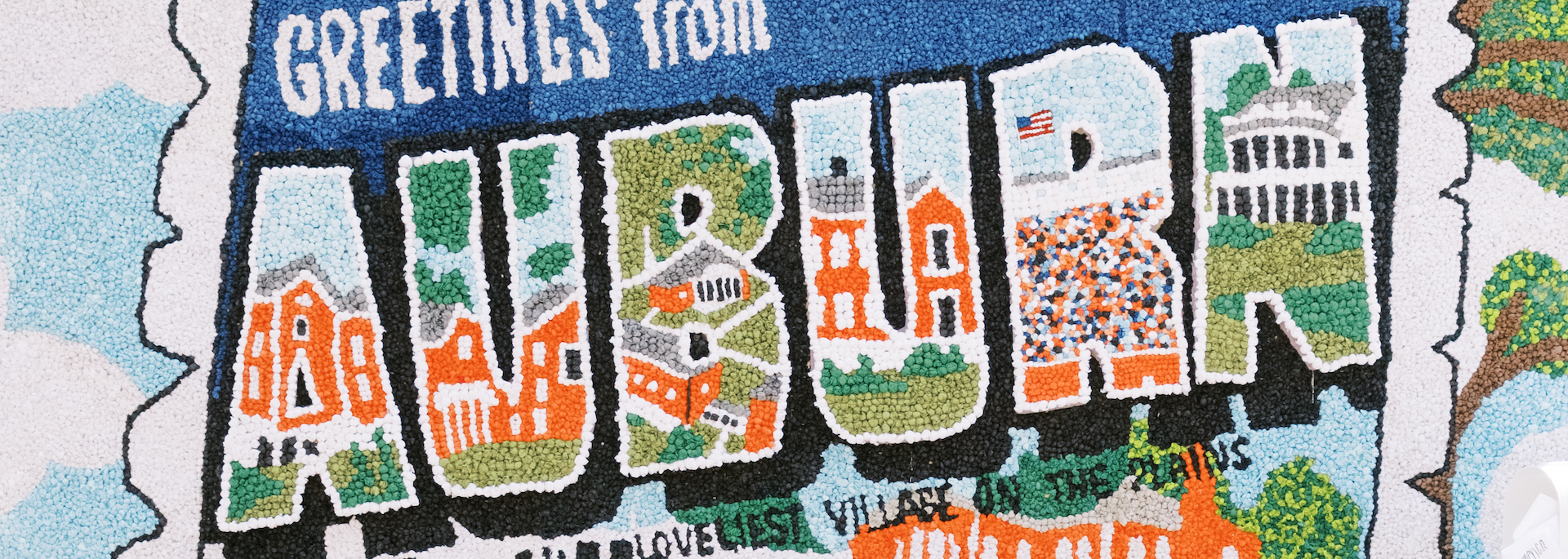 float in the homecoming parade that looks like a postcard and says Greetings from Auburn, the loveliest village on the plains