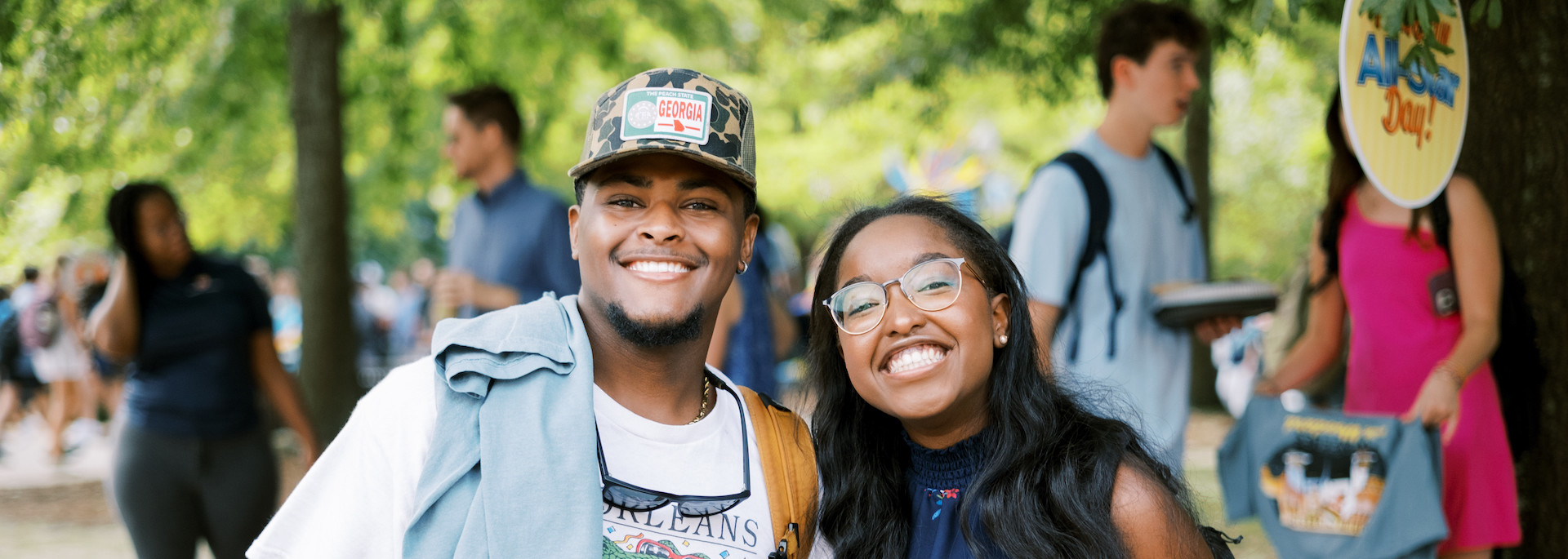 two students posing under the trees at the waffles with woodard event