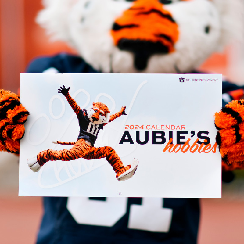 Aubie holding the 2024 Aubie calendar