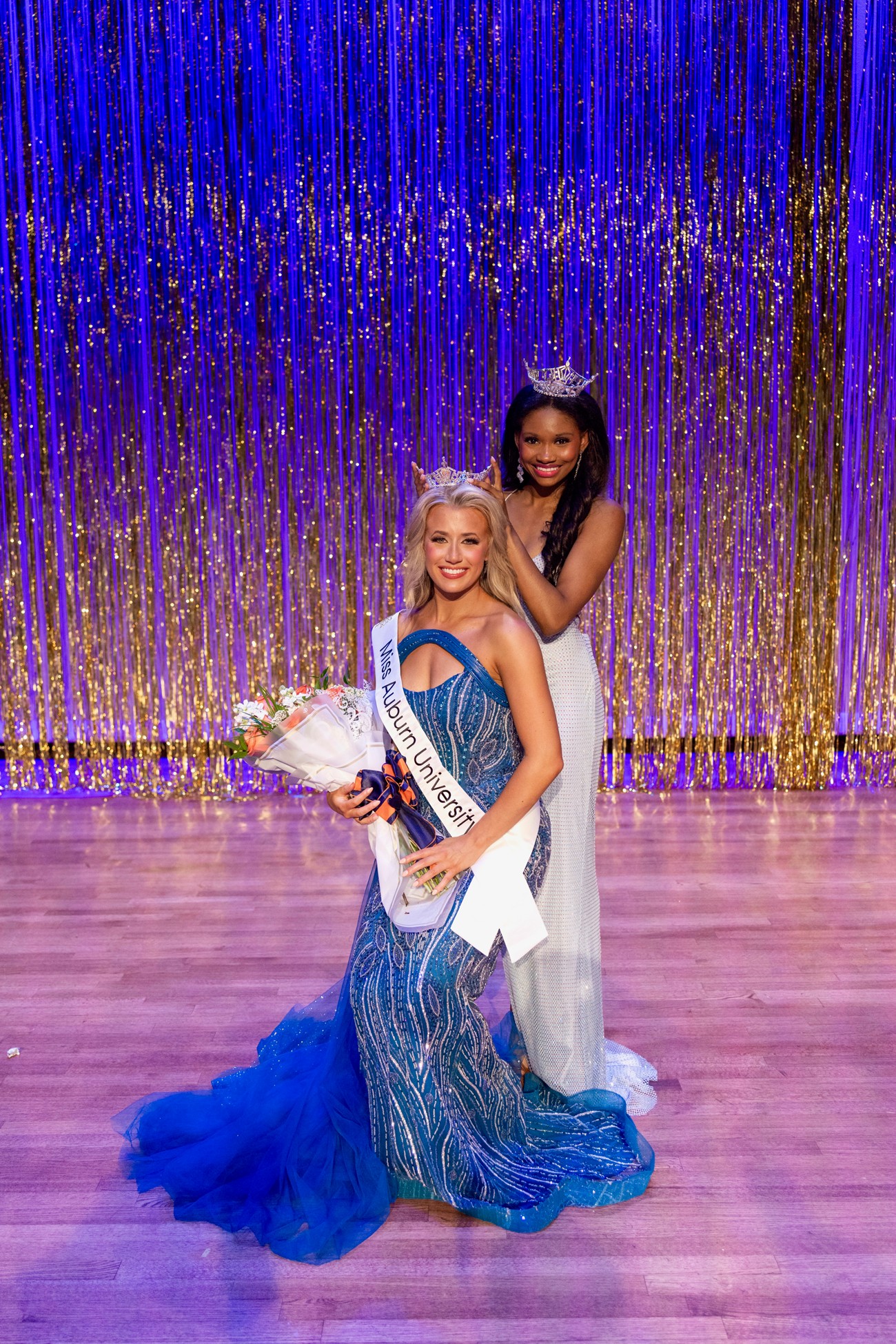 Two girls smiling on stage