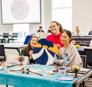 three students representing a student organization at a table during the involvement fair