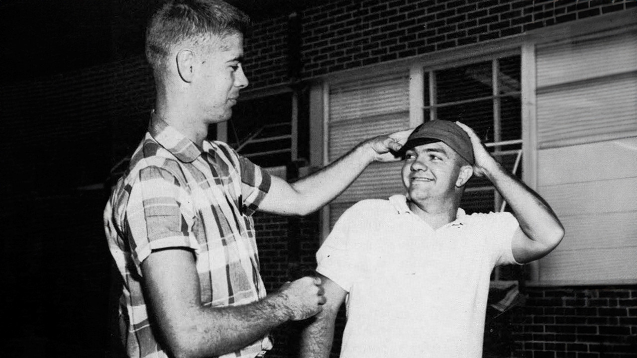 An Auburn student in the 1960s giving another student his RAT cap