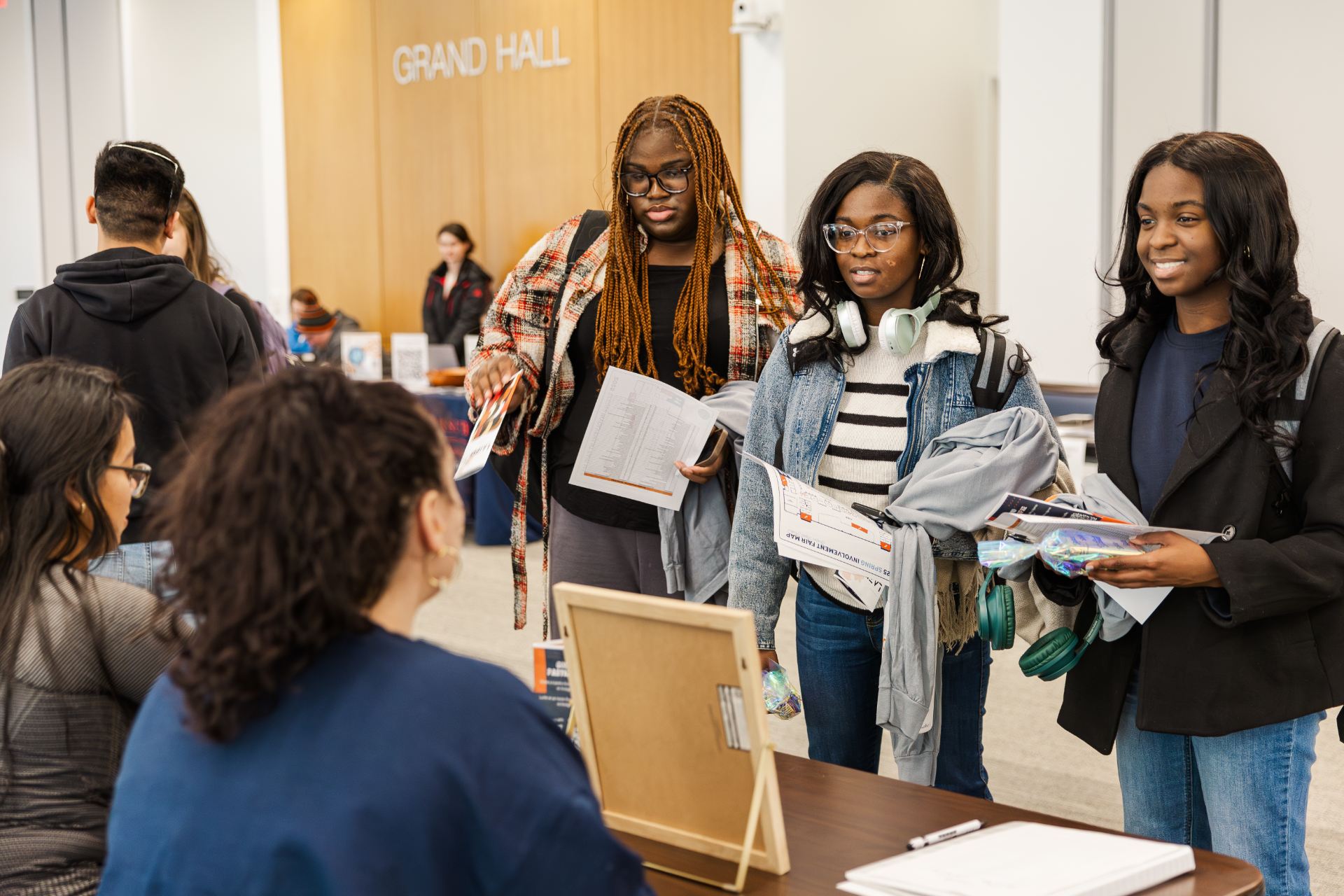 students standing at a table during the spring involvement fair