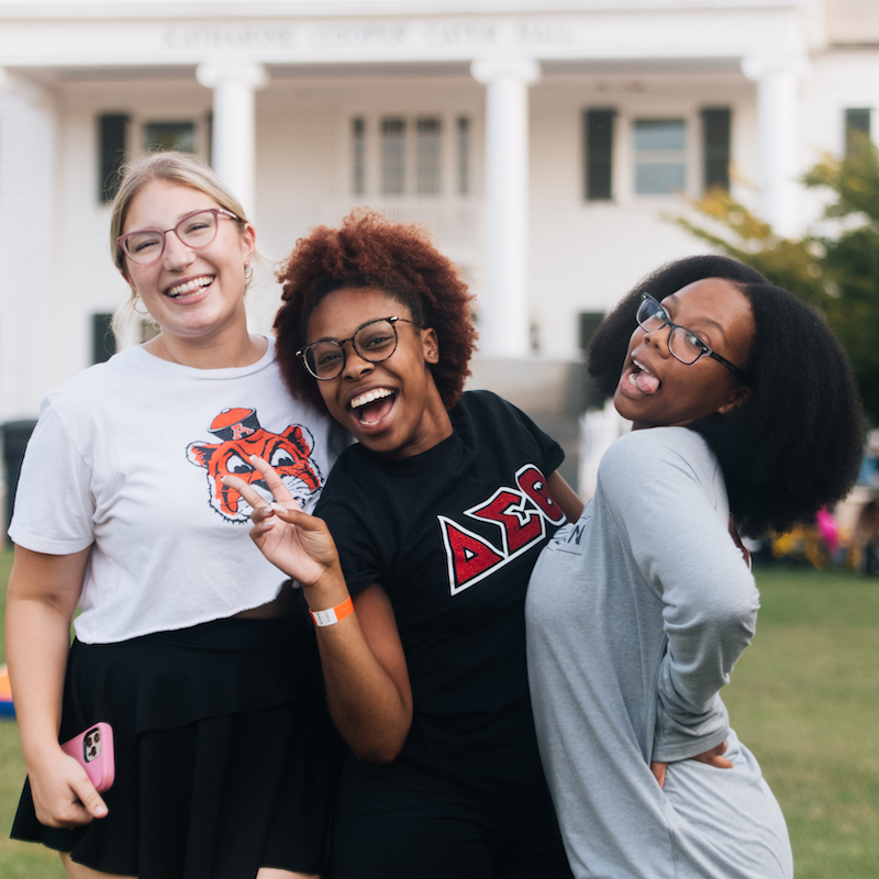 Three students pose for a photo in front of Cater hall