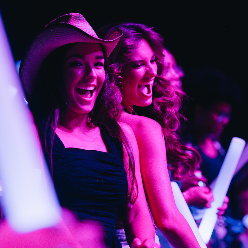 Two girls dancing at a concert