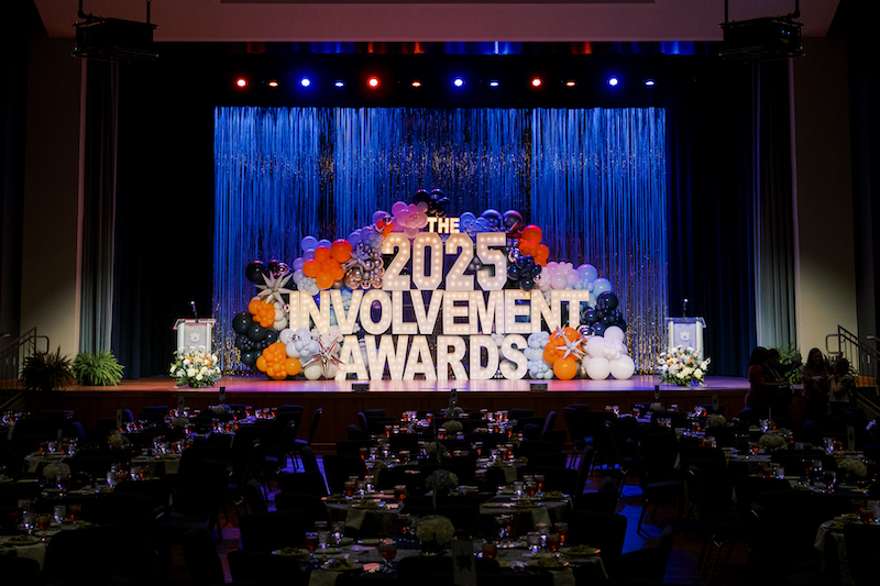 students taking a group selfie on stage in front of the Involvement Awards sign