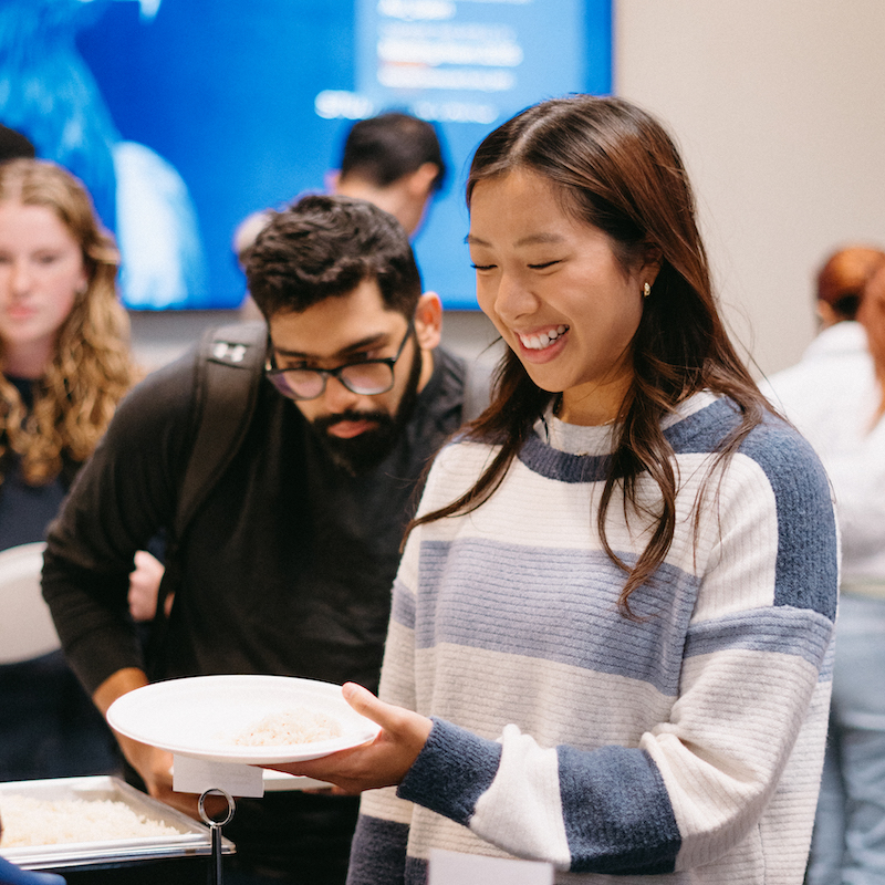 A student in line holding a plate with rice