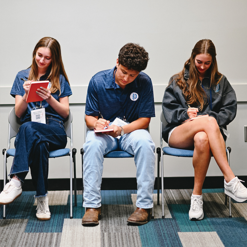 students seated around a table with a laptop